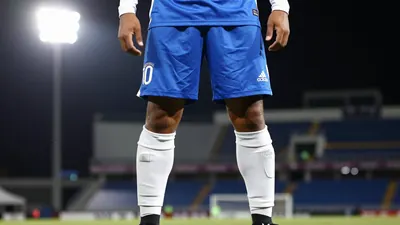 A 25-year-old, 5'9'' tall, Queretaro player in a blue jersey with white sleeves, wearing a white pair of socks, and a...